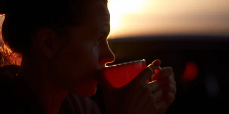 woman drinking coffee at sunrise
